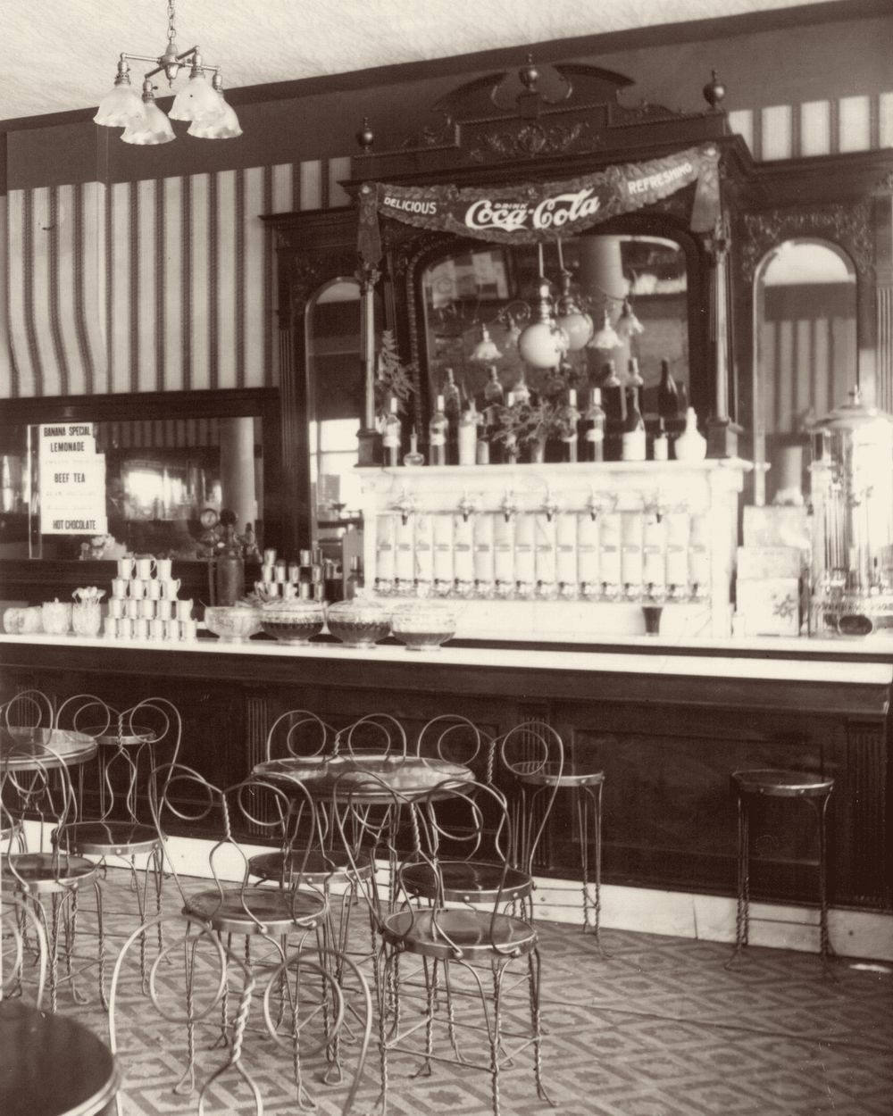 A soda fountain with a Coca-Cola banner, 1909